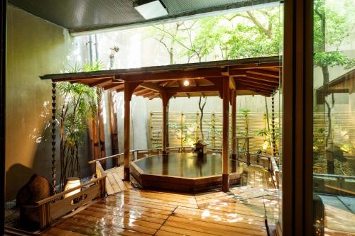 an outdoor hot tub on a wooden deck with a glass door at Hatori in Kaga
