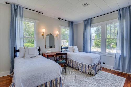 a bedroom with two beds and a desk and windows at Noble Cottage 3 Bed 1 Bath in Augusta
