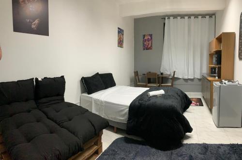 a bedroom with a bed and a couch at Studio 308 - Apartamento Passo Fundo in Passo Fundo