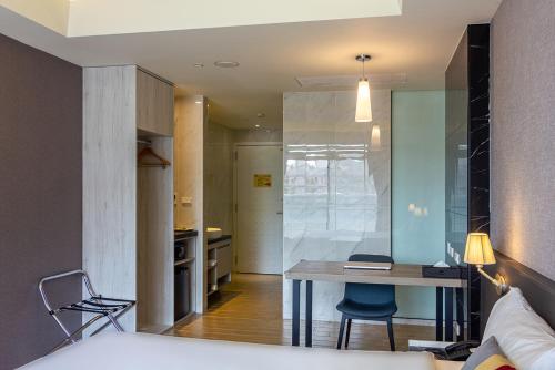 a bedroom with a bed and a desk in a room at CHECK inn New Taipei LuZhou in Taipei