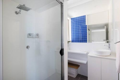 a white bathroom with a sink and a shower at Blue Vista in Nelson Bay