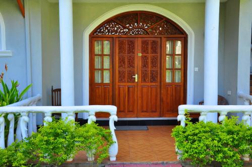 a wooden door with two benches in front of it at Bougain Villa in Bentota