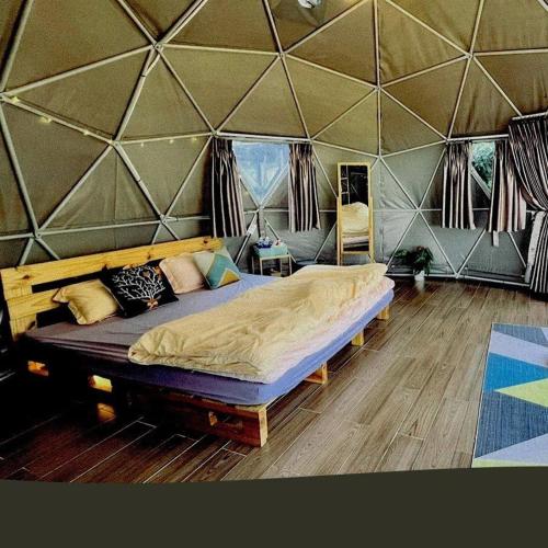a bedroom with a large bed in a tent at Đamb'ri Top View Farmstay & Glamping in Bao Loc