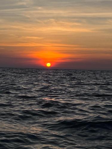a sunset over the ocean with the sun setting at Thani Ecobeach Barú in Playa Blanca