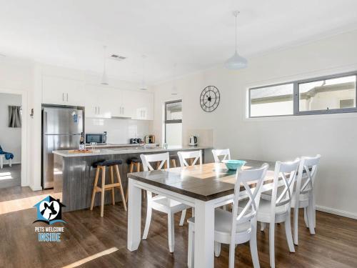 een keuken en eetkamer met een tafel en stoelen bij Ocean & Island Views for Miles – 4BR + 2.5 Baths in Encounter Bay