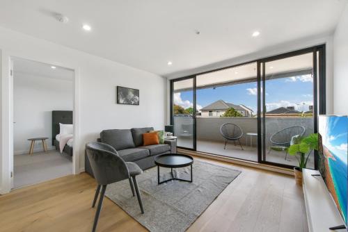 a living room with a couch and a table at Queensview168 Apartments Moonee Ponds in Melbourne