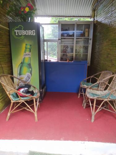 una máquina de bebidas con 2 sillas y una botella de refresco en Hotel new bamboo palace, en Gorkhā
