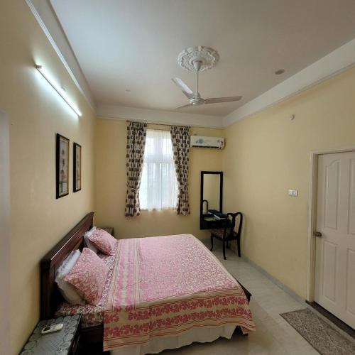 a bedroom with a pink bed and a window at Vazeer Residancy in Hyderabad