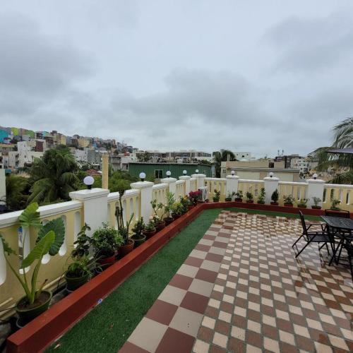 a balcony with a checkered floor and a patio with plants at Vazeer Residancy in Hyderabad