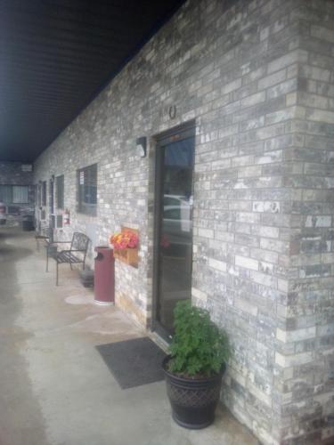 a brick building with a door and a potted plant at Coachman's Inn & Suites in Waldron