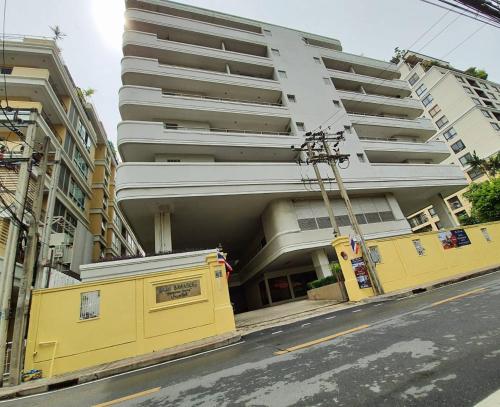 a large white building on a city street at Baan Sawasdee Residence in Bangkok