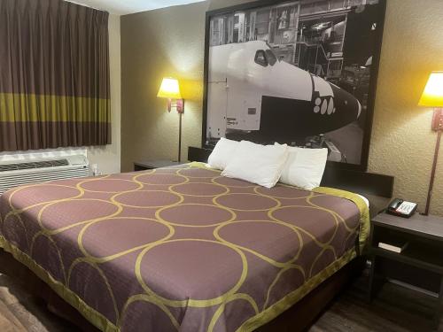 a hotel room with a bed and a picture on the wall at Super 8 by Wyndham La Marque TX/Texas City Area in La Marque