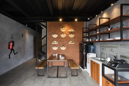 Una cocina con una mesa y una pared de ladrillos. en Cove W Suites, en Yakarta
