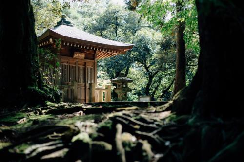 a small building in a forest with trees at Rurikoh in Kaga