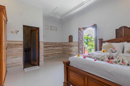 a bedroom with a large bed and a bathroom at Manta Cottages with Sea View in Nusa Penida