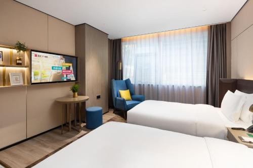 Postel nebo postele na pokoji v ubytování Echarm Plus International Hotel Hangzhou Binjiang XingGuang Avenue Pedestrian Street Branch
