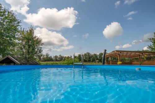 a swimming pool with a blue sky and clouds at Ferienwohnung Bichler in Altötting