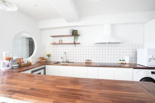 a kitchen with white cabinets and a wooden floor at Stay moment in Busan