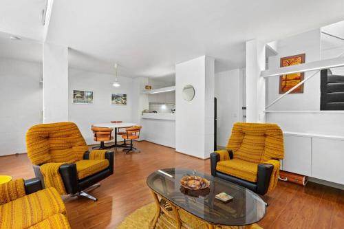 a living room with two chairs and a table at The Warbling Magpie in Melbourne