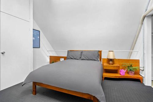 a bedroom with a bed and a table with a lamp at The Warbling Magpie in Melbourne