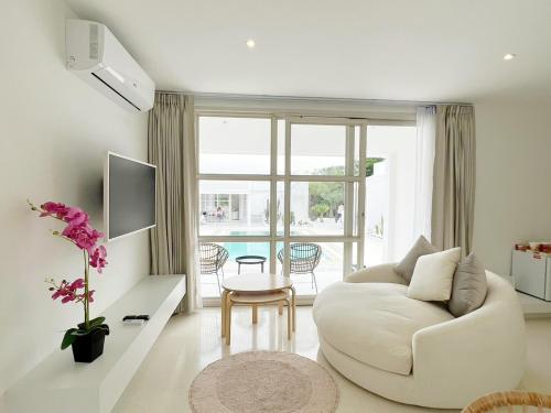 a white living room with a white couch and a table at ทิพย์วาริน รีสอร์ท เขาใหญ่ in Ban Tha Chang
