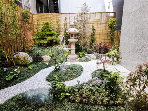 einen Garten mit einem Brunnen in der Mitte eines Gebäudes in der Unterkunft HOTEL UNIZO Osaka Umeda in Osaka