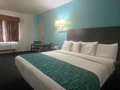 um quarto de hotel com uma cama grande e uma mesa em Howard Johnson by Wyndham Galveston em Galveston