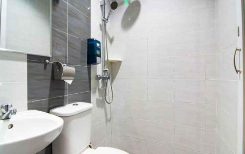 a bathroom with a shower and a toilet and a sink at Avaria Signature Hotel in Melaka