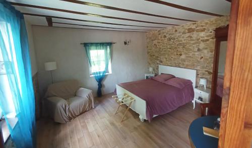 um quarto com uma cama e um sofá num quarto em Chambres Maison Labourdasse em Saint-Martin-de-Hinx