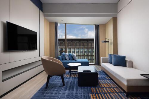 a living room with a couch and a tv at Four Points by Sheraton Guangzhou, Baiyun in Guangzhou