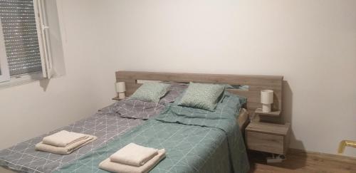 een slaapkamer met een bed met 2 kussens erop bij Jószerencsét apartman in Komló