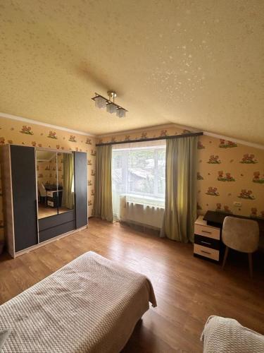 a bedroom with a bed and a desk and a window at Комнаты у Айрин in Vanadzor