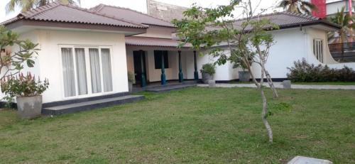a house with a small tree in the yard at Golden Star Beach Hotel in Negombo