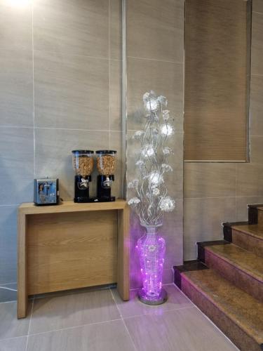 a purple vase with flowers in a room at Hotel Laon in Tongyeong