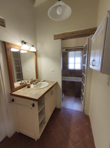 a bathroom with a sink and a mirror and a shower at Casa Colonial "Dulce Hogar" in Baños