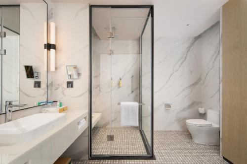 a bathroom with a shower and a toilet and a sink at Element Guangzhou Baiyun in Guangzhou
