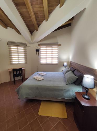 sypialnia z dużym łóżkiem i 2 oknami w obiekcie Casa Colonial "Dulce Hogar" w Baños