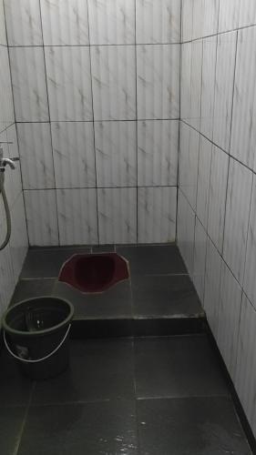 un baño sucio con un cubo en el suelo en Babemhome en Karanganyar