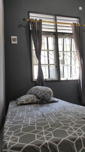 Bett in einem Schlafzimmer mit Fenster und Kissen in der Unterkunft Babemhome in Karanganyar