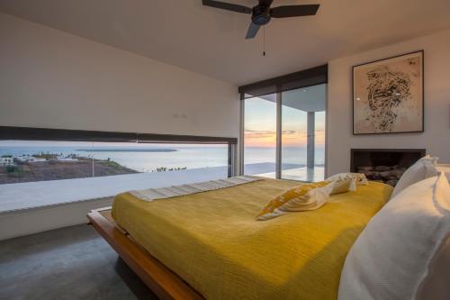 a bedroom with a large yellow bed with a large window at Villa Wellmina - Stunning Sunsets & Relaxing Poolside Vibes! in La Paz