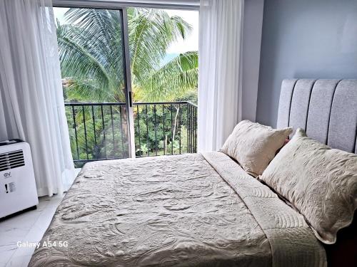 a bedroom with a bed and a large window at Casa Victoria CR in San Isidro