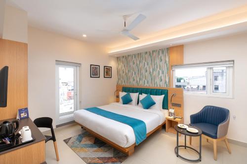 um quarto com uma cama, uma secretária e uma cadeira em Cozzet Victoria Hotel em Bhubaneshwar