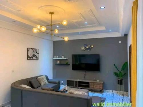 a living room with a couch and a flat screen tv at Appartement chic & classe in Pointe-Noire