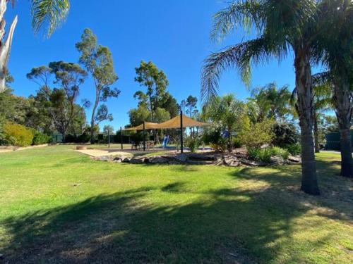 a park with palm trees and a gazebo at Lambert's Little Paradise in Altona