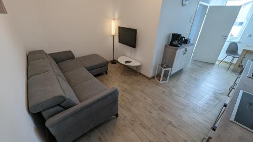 sala de estar con sofá y TV en Ferienwohnung Am Kleinen Haff, en Garz