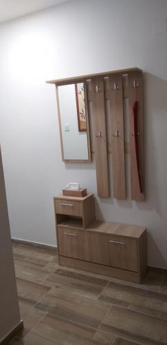 een kleedkamer met houten kasten en een spiegel bij Jószerencsét apartman in Komló