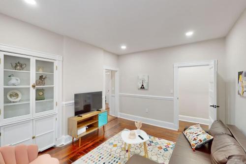 a living room with a couch and a tv at Forever Boston-5 mil Fenway, FreePrkg in Boston