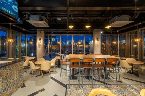 a restaurant with tables and chairs and a view of the city at Cozzet Victoria Hotel in Bhubaneshwar