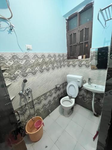 uma casa de banho com um WC e um lavatório em Joey's Homestay em Rishikesh