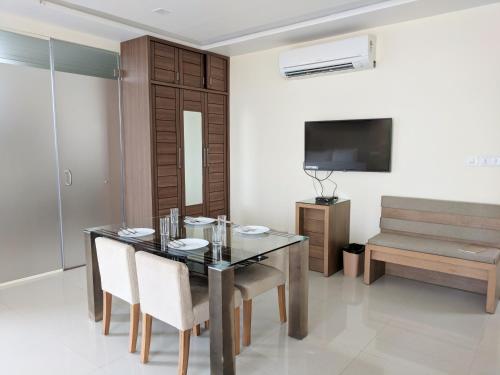 jadalnia ze stołem, krzesłami i telewizorem w obiekcie Clyford Suites w mieście Bengaluru